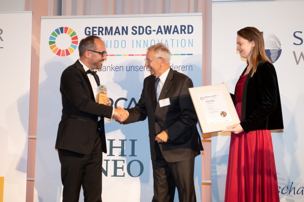 Preisverleihung des German SDG Award vom Senat der Wirtschaft Deutschland am 25.11.23 in München Maximilianeum, an Climate Nuts GmbHV.l.nr.: Christoph Schaaf (CEO Climate Nuts), Dieter Overath (Ehemaliger geschäftsführender Vorstandsvorsitzender Fairtrade Deutschland e.V.), Svenja Reimer (Projektbeauftragte German SDG-Award)<br> Bildrechte: Senat der Wirtschaft Deutschland e.V.